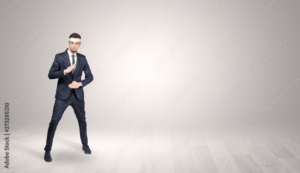 Young businessman in suit fighting in an empty space
Young businessman in suit fighting in an empty space