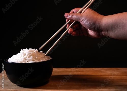 Rice in a bowl on a black background in the studio.