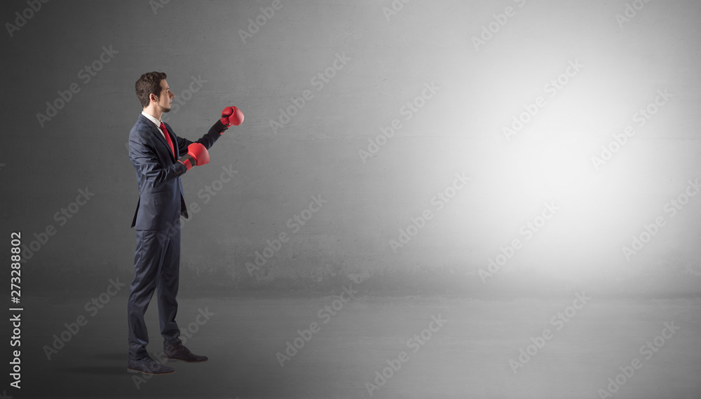 Businessman fighting with boxing gloves in an empty space
Businessman fighting with boxing gloves in an empty space