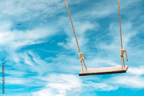 Bild auf Leinwand Wooden swing with pastel blue sky and cloud background