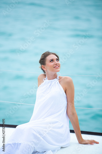 beautiful woman in white dress enjoying luxurious yacht cruise