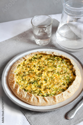 Tart with eggs and green onions on a plate