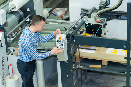 portrait of factory worker switching levers on big machines photo