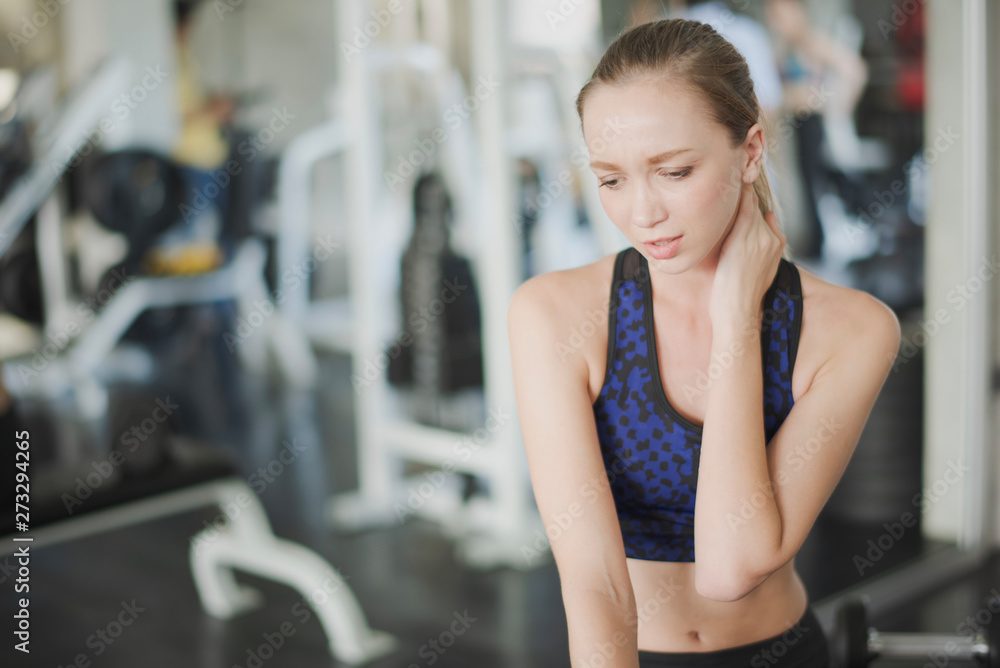 Young Woman have muscle pain at neck while workout at gym. Accident weight training at fitness, muscle pain concept. Young Woman have muscle pain at neck while workout at gym. Accident weight training at fitness, muscle pain concept.