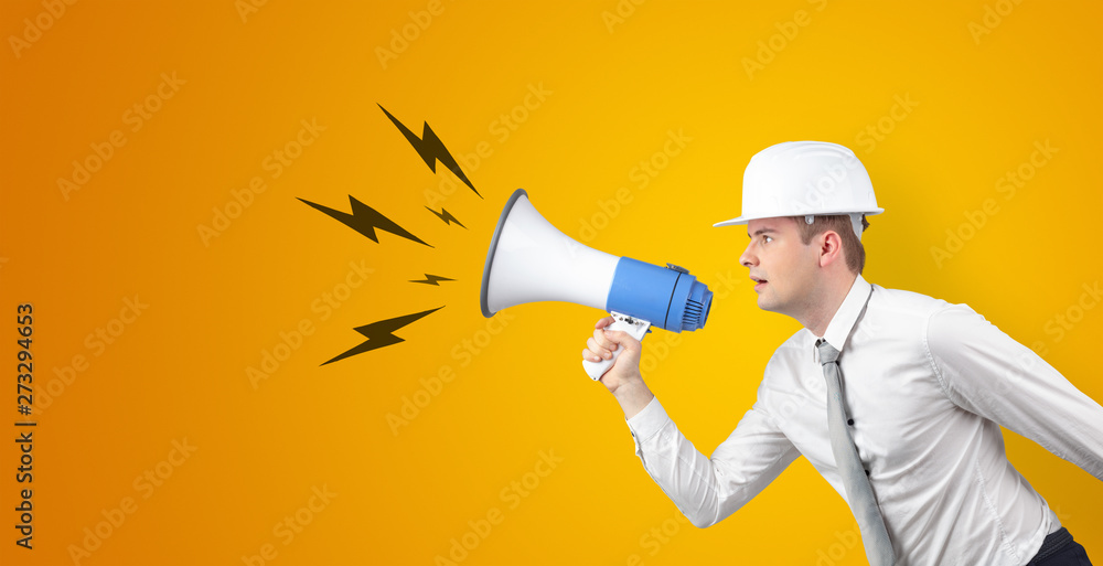 Fototapeta premium Young architect constructor yelling with megaphone and copyspace