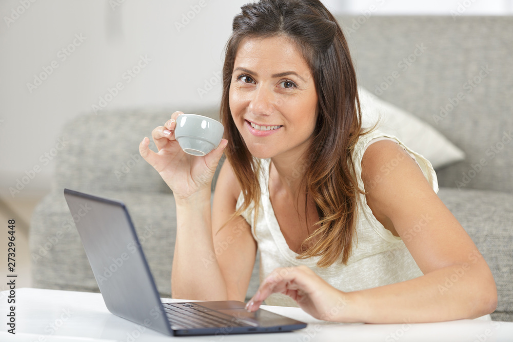 young smiling woman with cup of coffee and laptop young smiling woman with cup of coffee and laptop
