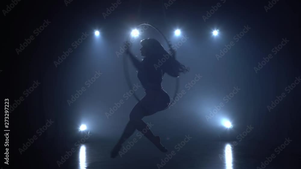 Aerial acrobat in the ring. A young girl performs the acrobatic elements in the air ring in the circus 080 Aerial acrobat in the ring. A young girl performs the acrobatic elements in the air ring in the circus 080