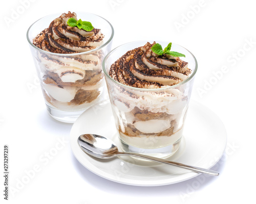 Classic tiramisu dessert in a glass on plate with spoon isolated on a white with clipping path