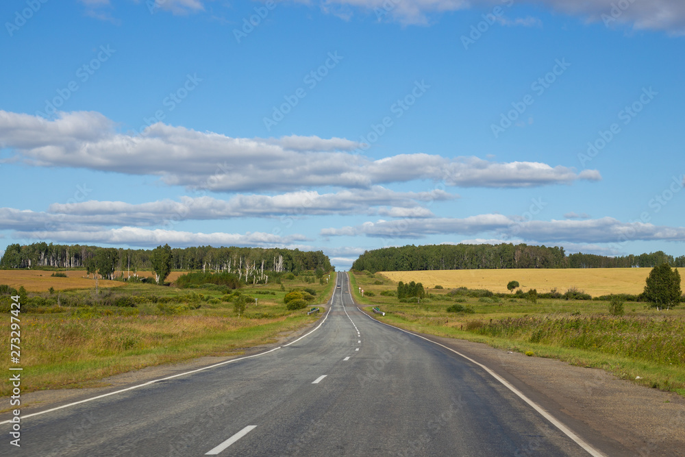 the road meanders away into the distance, on top of a cloudy sky