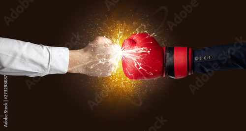 Two hands fighting with orange dust, spark, glow and smoke concept 
