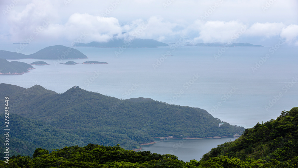 landscape and seascape mountain and the sea and shipping cargo containers in the rain season at viewpoint ngong ping 360 cable car in hong kong asia