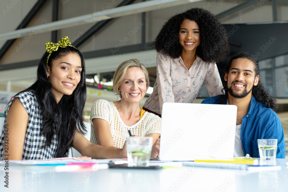 Business people looking at camera while working at conference room in a modern office
