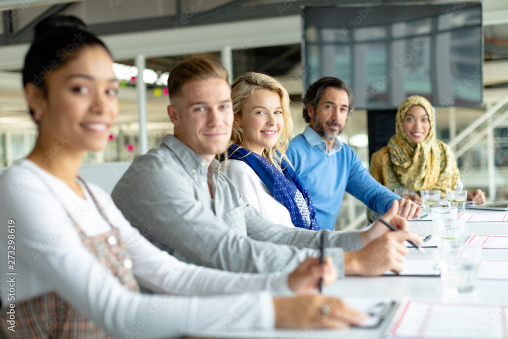 Business people looking at the camera during a business meeting in a modern office Business people looking at the camera during a business meeting in a modern office