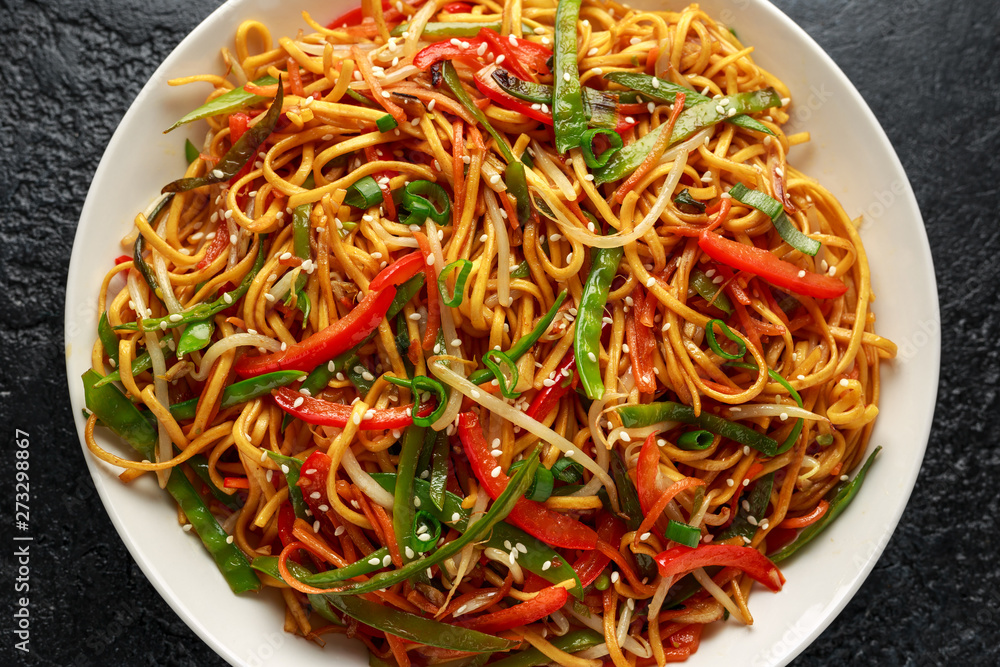 Chow mein, noodles and vegetables dish with wooden chopsticks Chow mein, noodles and vegetables dish with wooden chopsticks