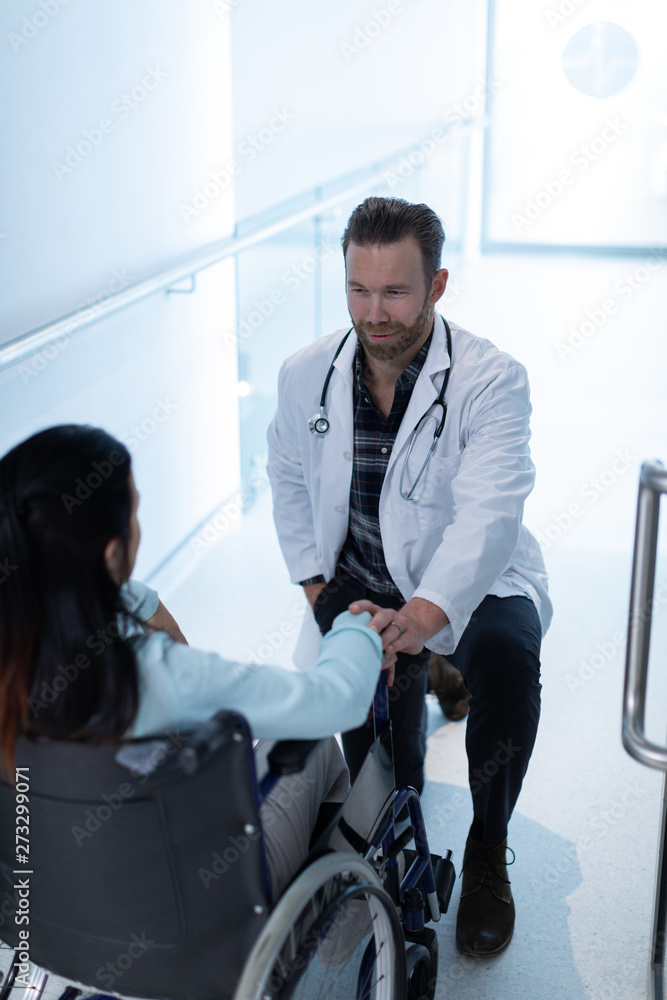Male doctor consoling female patient in the corridor Male doctor consoling female patient in the corridor