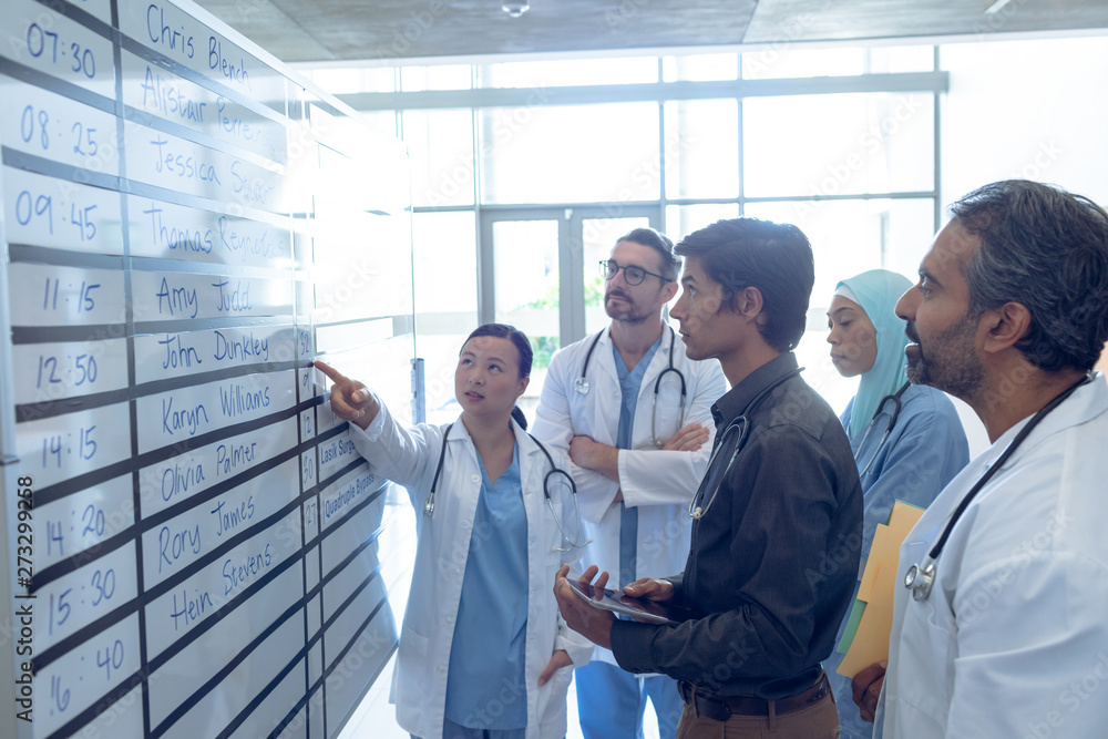 Medical team of doctors discussing their shifts on chart at hospital Medical team of doctors discussing their shifts on chart at hospital