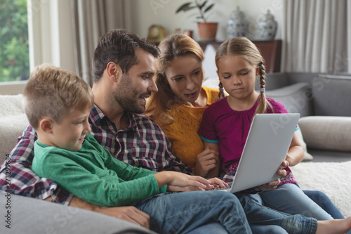 Caucasian family using laptop on the sofa in a comfortable home