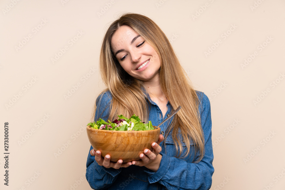 Young woman with salad over isolated background Young woman with salad over isolated background
