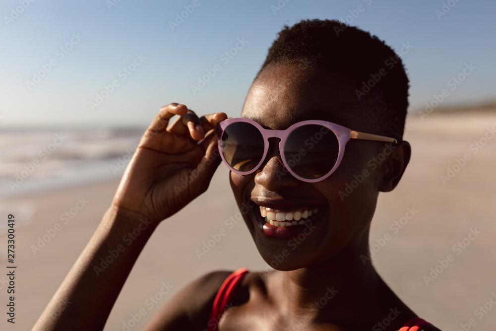 Woman in sunglasses standing on the beach Woman in sunglasses standing on the beach
