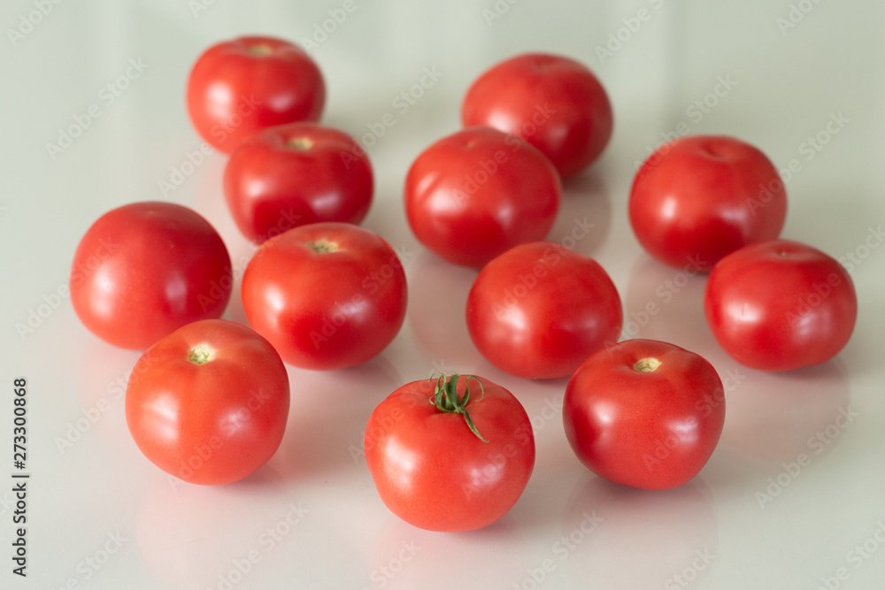 Fresh tomatoes on a white glass table. Harvesting tomatoes. Top view. Fresh tomatoes on a white glass table. Harvesting tomatoes. Top view.