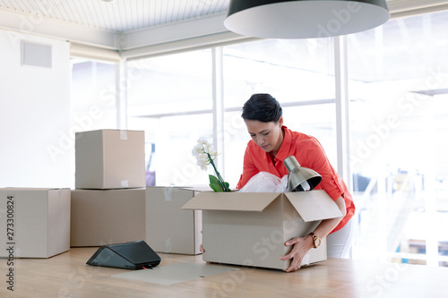 Businesswoman holding cardboard boxes in new office
