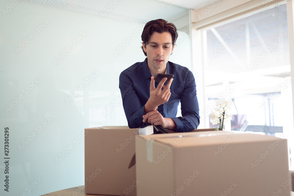Male executive talking on mobile phone in office Male executive talking on mobile phone in office