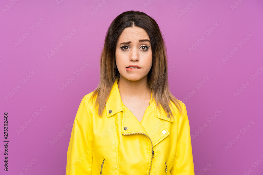 Young woman over purple background having doubts and with confuse face expression Young woman over purple background having doubts and with confuse face expression