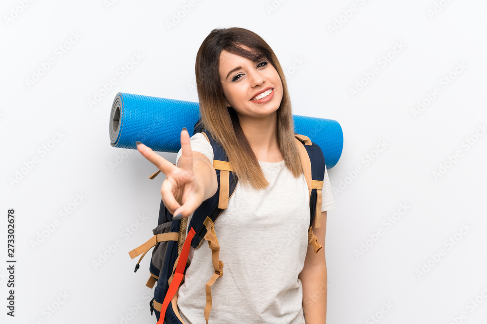 Young traveler woman over white background smiling and showing victory sign Young traveler woman over white background smiling and showing victory sign
