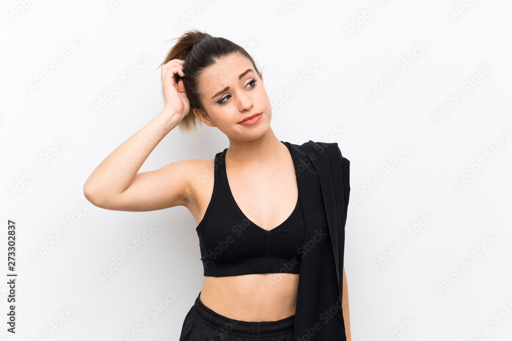 Young sport woman over white wall having doubts and with confuse face expression Young sport woman over white wall having doubts and with confuse face expression