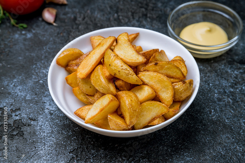 The potatoes wedges with cheese sause on bowl