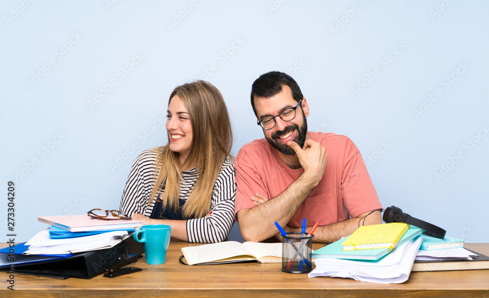 Students with many books with arms crossed and happy Students with many books with arms crossed and happy