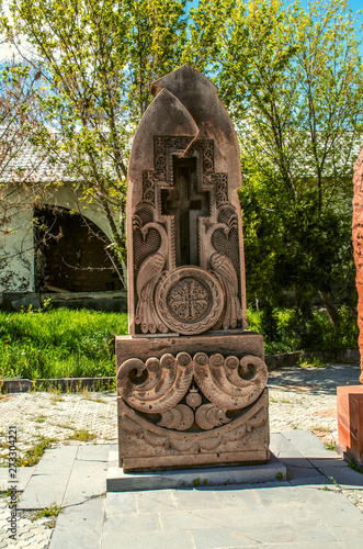 Stylized peacocks carved on a gray stone khachkar in a Park near the Church of the Holy Martyrs in the village of Teghenik in Armenia photo