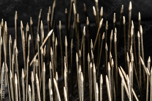 A macro image of steel sewing straight pin points in a very disorganized grouping  enough to drive an OCD person crazy.