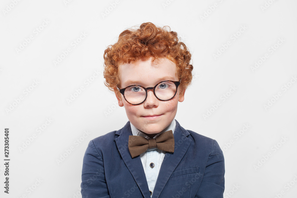 Redhead boy in blue suit with bow tie on white Redhead boy in blue suit with bow tie on white