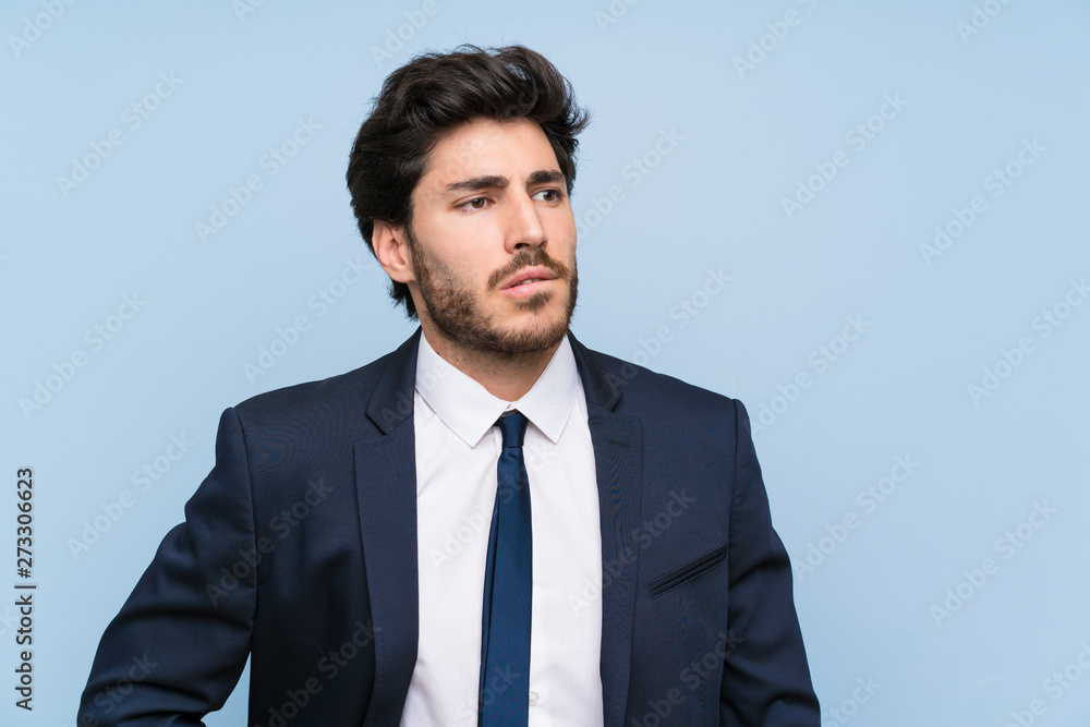 Businessman over isolated blue wall with confuse face expression Businessman over isolated blue wall with confuse face expression