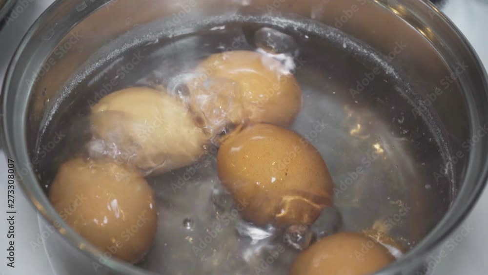 Chicken eggs are boiled in a saucepan in boiling water Chicken eggs are boiled in a saucepan in boiling water
