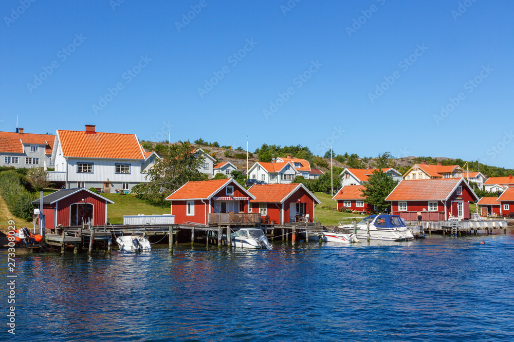 Boats at the pier with boat house on the Swedish coast