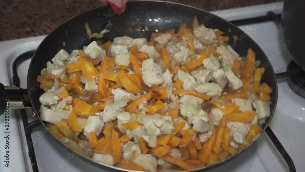 Chicken meat, carrots, onions are cooked in a pan Chicken meat, carrots, onions are cooked in a pan