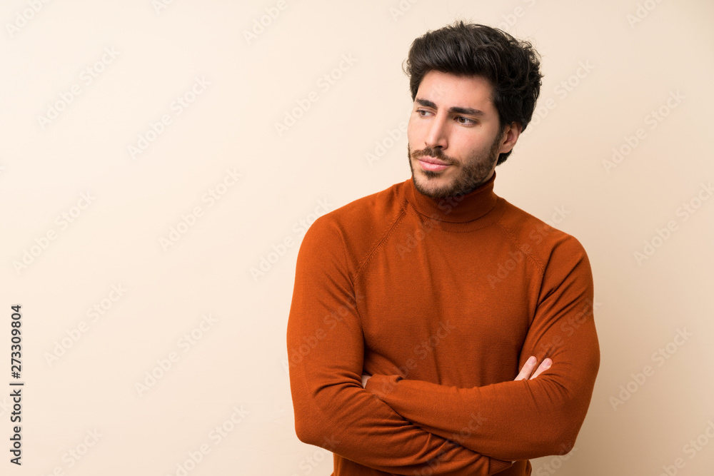 Handsome over isolated wall standing and thinking an idea Handsome over isolated wall standing and thinking an idea