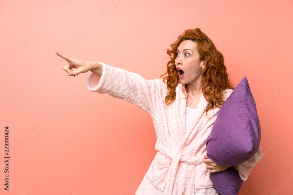 Redhead woman in dressing gown pointing finger to the side Redhead woman in dressing gown pointing finger to the side