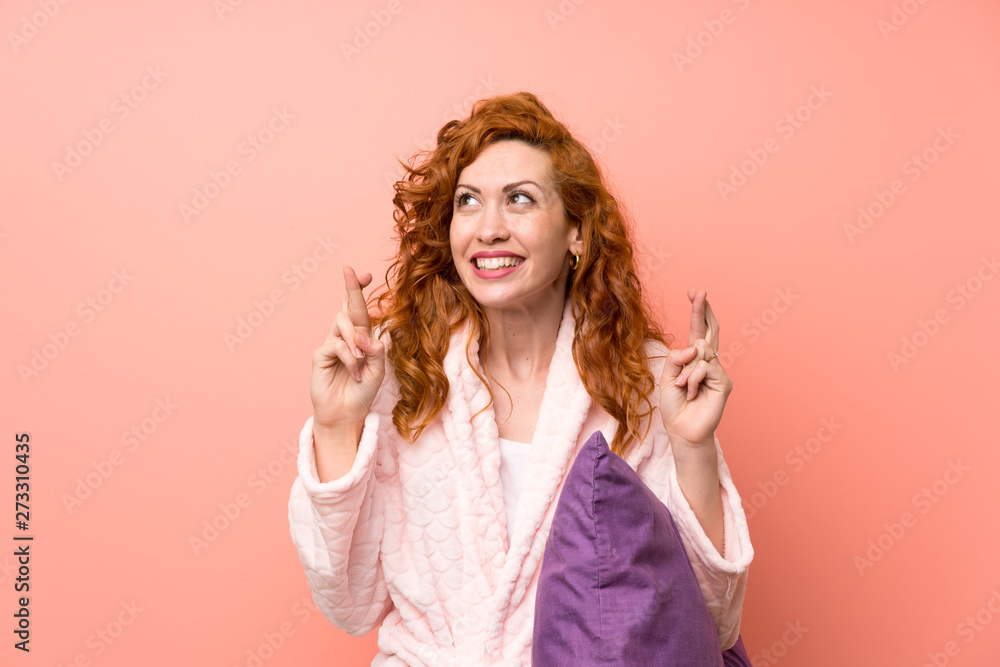 Redhead woman in dressing gown with fingers crossing Redhead woman in dressing gown with fingers crossing