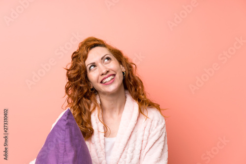 Redhead woman in dressing gown laughing and looking up © luismolinero