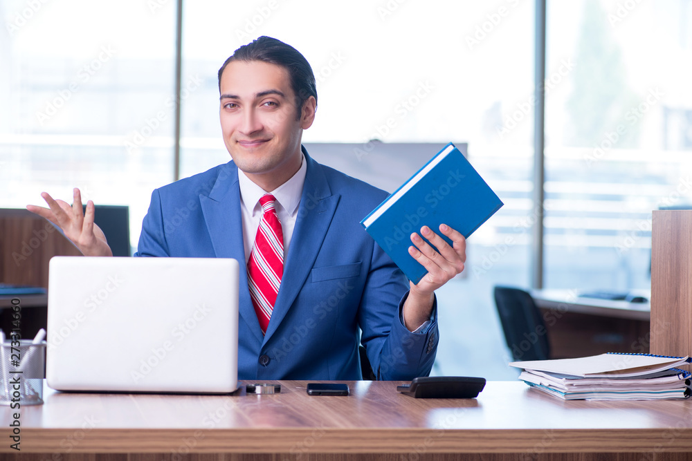 Young handsome businessman sitting in the office Young handsome businessman sitting in the office