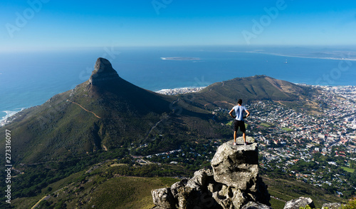 A hiker looking out over Cape Town from the top of Table Mountain © Andre