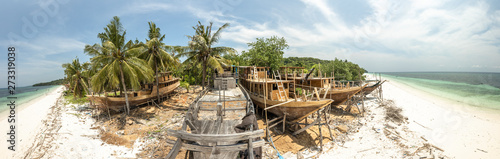 Panorama of a habor contructing wooden boads between palm trees at the beach