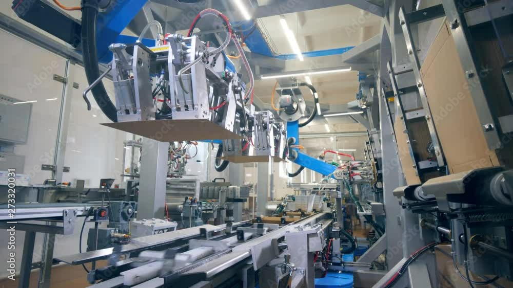 Carton boxes are getting formed by an industrial machine. Modern factory equipment. Carton boxes are getting formed by an industrial machine. Modern factory equipment.