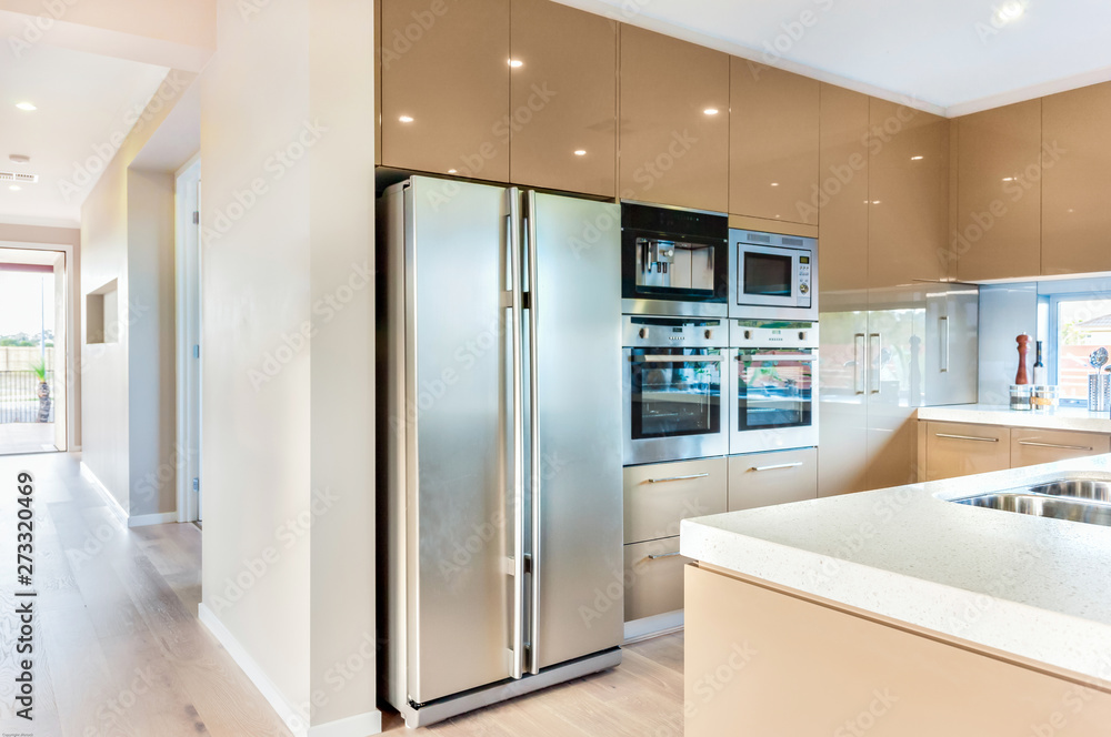 A modern refrigerator in the luxury kitchen with microwave ovens fixed to the wall - obrazy, fototapety, plakaty 
