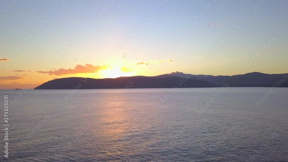 Aerial Drone Shot Flying Over a Man Waving on a Coastal Cliff at Sunset in Elba, Italy Aerial Drone Shot Flying Over a Man Waving on a Coastal Cliff at Sunset in Elba, Italy