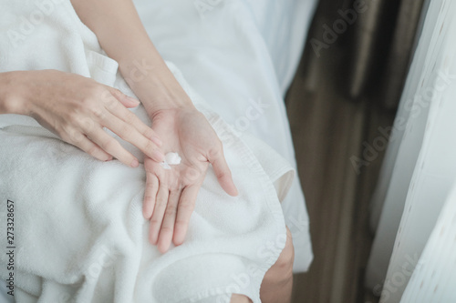 Woman applying moisturizing cream/lotion on hands, Top View, beauty concept.