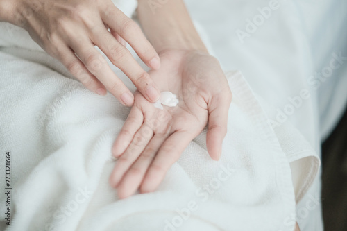 Woman applying moisturizing cream lotion on hands  Top View  beauty concept.